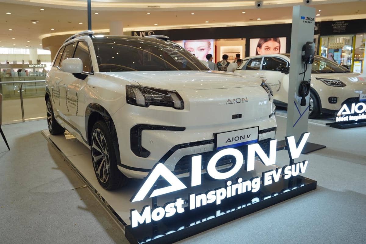 Mobil listrik Aion V berwarna putih dipamerkan di dalam pusat perbelanjaan dengan papan nama bercahaya di bagian depan.