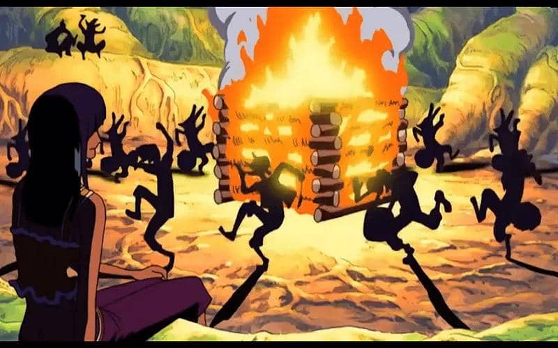 Adegan animasi tarian di sekitar api unggun besar pada malam hari di arc Skypiea dari serial One Piece.