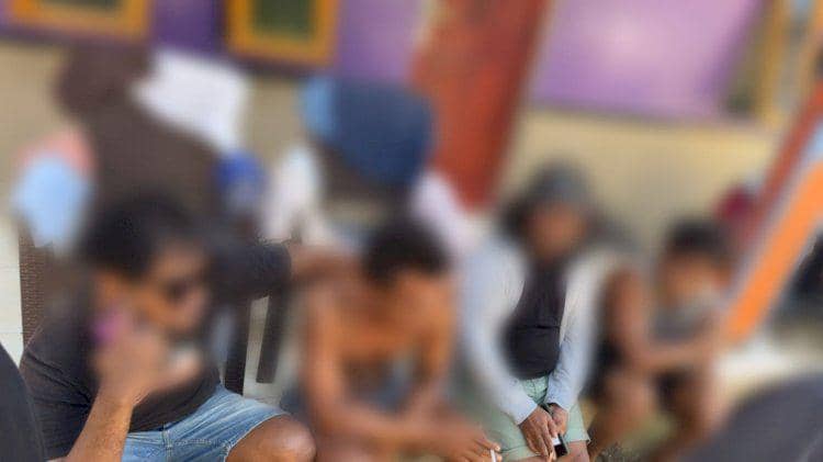 Beberapa orang duduk di luar ruangan saat penggerebekan pengguna narkoba oleh Polres Manggarai Barat di Labuan Bajo.