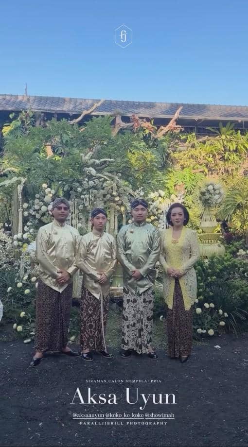 Empat orang mengenakan busana tradisional Jawa berwarna emas dan cokelat berpose di depan dekorasi bunga pada acara siraman dan sungkeman.