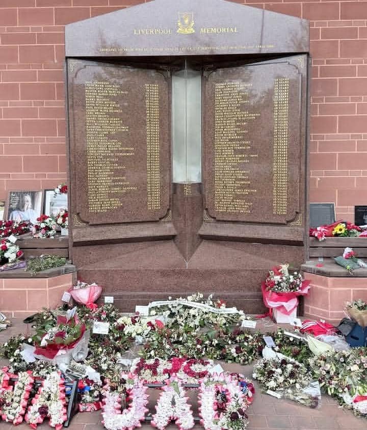 Tugu peringatan Liverpool di Stadion Anfield dengan nama-nama korban terukir di batu marmer dan bunga penghormatan di sekitarnya.