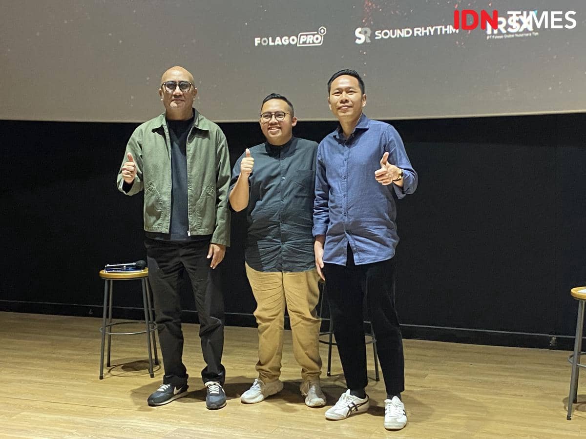 Tiga pria berpose sambil mengacungkan jempol di depan layar saat konferensi pers pengumuman konser Westlife di Jakarta tahun 2027.