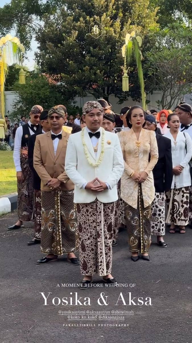 Rombongan keluarga mengenakan busana adat Jawa dengan batik dan blangkon saat prosesi akad pernikahan di luar ruangan.