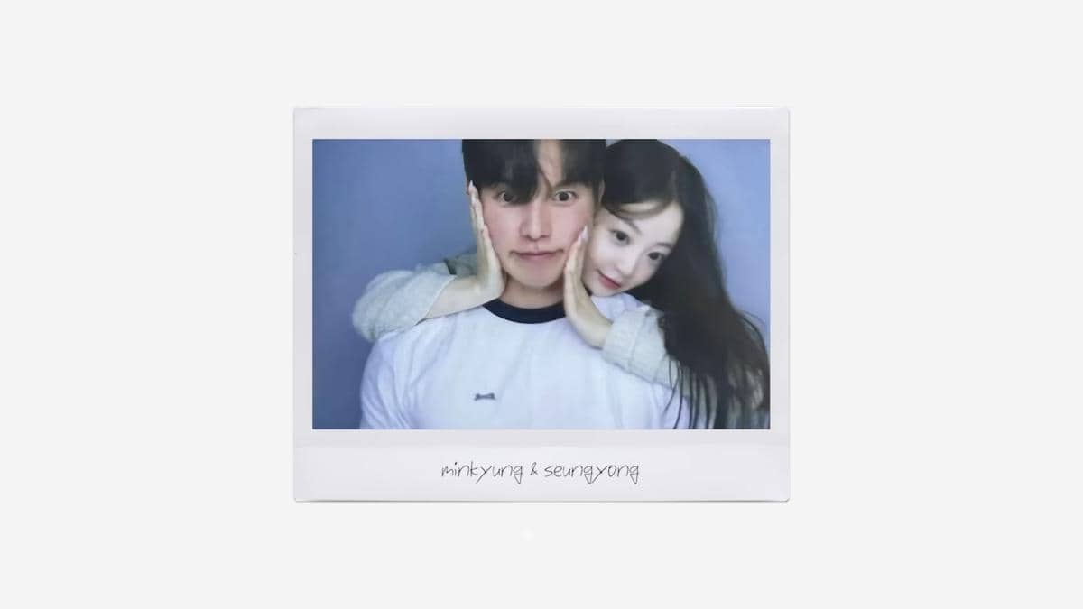 Sepasang pria dan wanita berpose lucu dalam foto polaroid dengan latar belakang biru, tampak saling berdekatan dan tersenyum hangat.