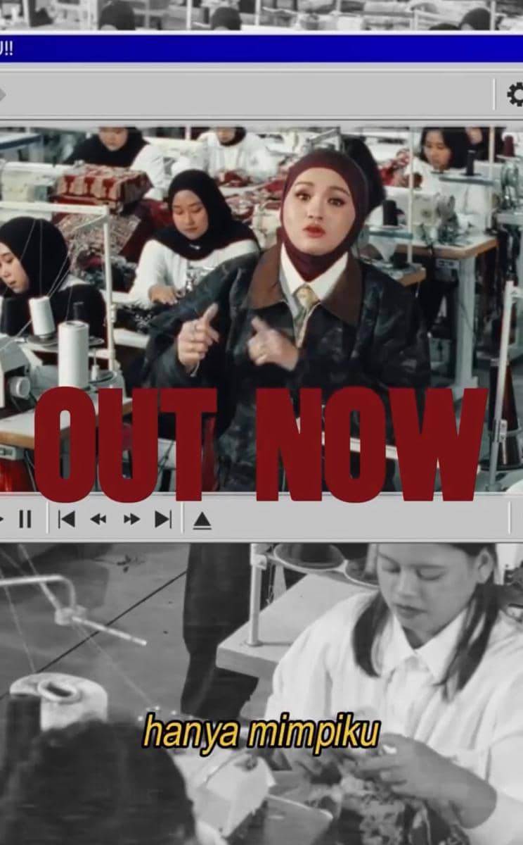 Seorang perempuan berhijab bernyanyi di antara para pekerja pabrik jahit dengan teks besar bertuliskan 'OUT NOW' di layar video.