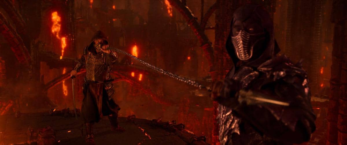 Dua prajurit bertopeng bertarung dengan senjata di lingkungan gelap bernuansa merah api dalam adegan film Mortal Kombat 2.