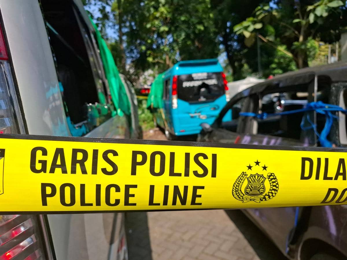 Beberapa kendaraan wisatawan dengan kaca pecah dipasangi garis polisi berwarna kuning di area Pantai Wedi Awu, Malang.
