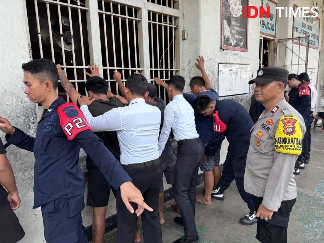 Petugas gabungan memeriksa narapidana yang berdiri menghadap tembok saat razia di Lapas Pemuda Kelas IIA Tangerang.