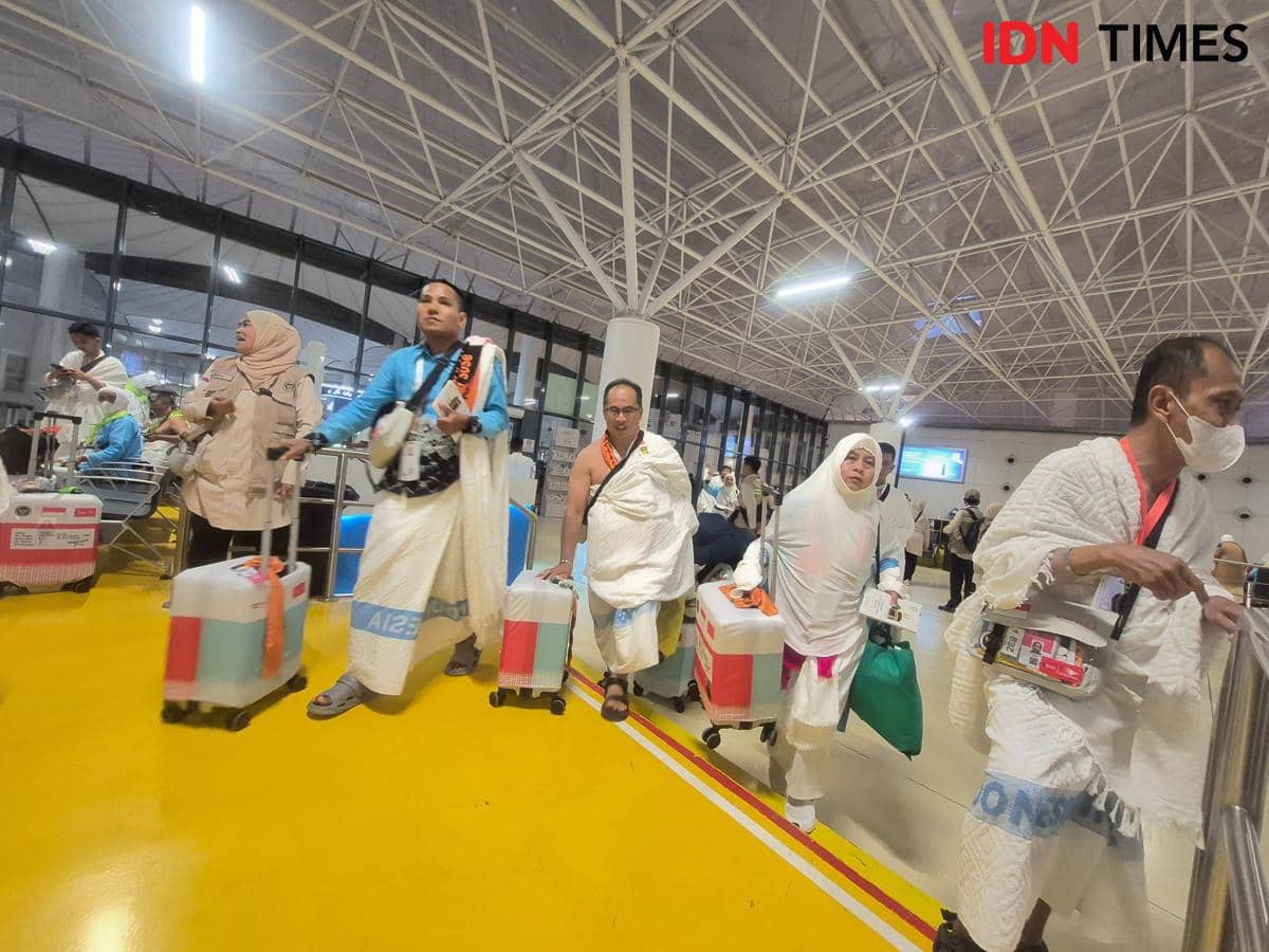 Jemaah haji asal Indonesia mengenakan pakaian ihram tiba di Bandara Internasional King Abdul Aziz Jeddah sambil membawa koper dan perlengkapan ibadah.