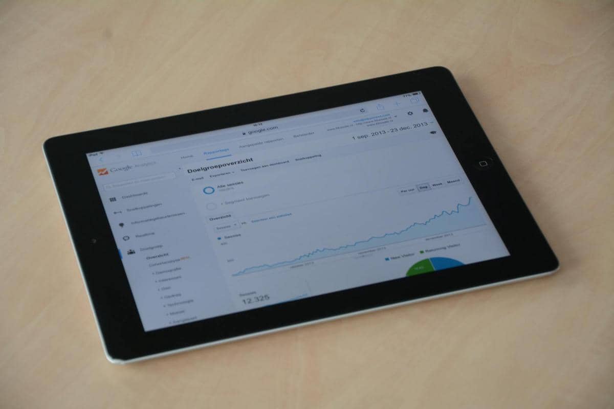 Tablet hitam di atas meja menampilkan grafik peningkatan data pengguna internet dengan antarmuka analitik daring.