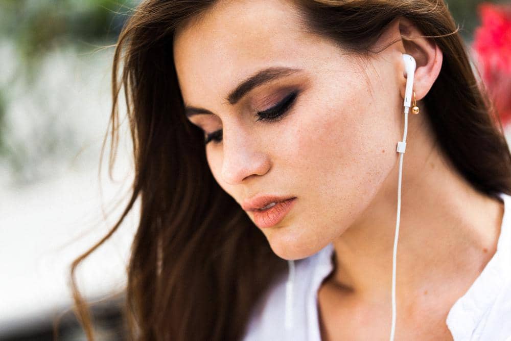 perempuan berambut cokelat dengan headset yang terpasang di telinganya