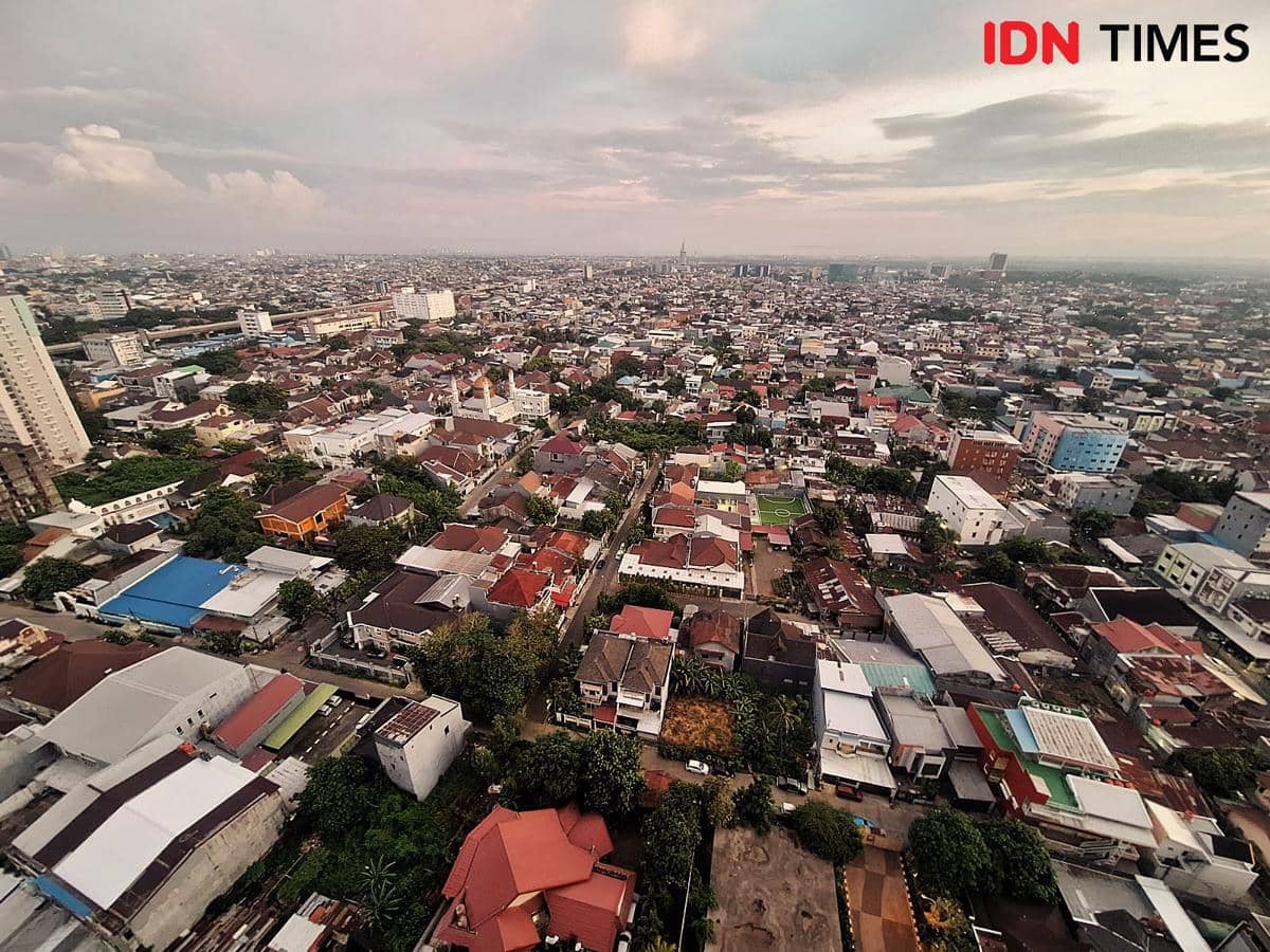 Pemandangan udara Kota Makassar pada Oktober 2025 dengan deretan bangunan padat, jalanan kota, dan langit senja berawan.