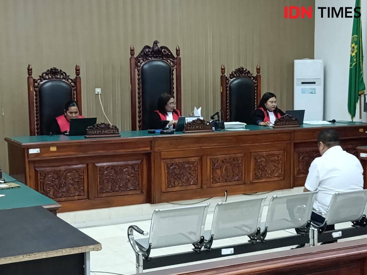 Tiga hakim Pengadilan Negeri Kupang mengenakan toga merah hitam saat membacakan putusan terhadap mantan anggota Polda NTT di ruang sidang.