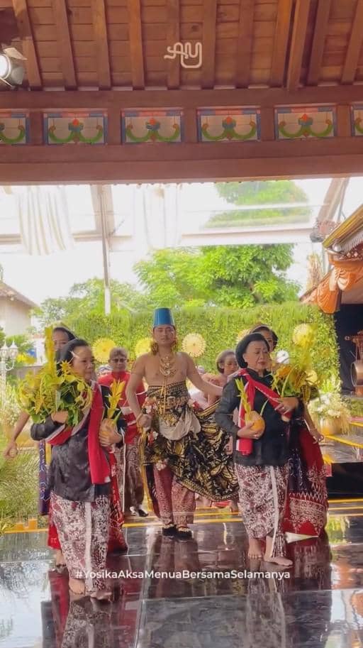 Prosesi ngunduh mantu adat Jawa dengan pengantin pria mengenakan busana tradisional dan diiringi para penari membawa sesaji.