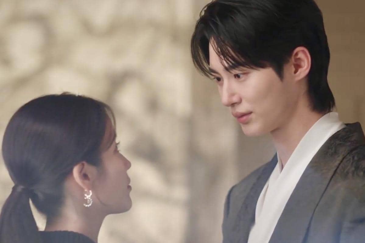 Dua karakter dalam drama Korea Perfect Crown saling menatap dengan ekspresi lembut di ruangan bercahaya hangat.