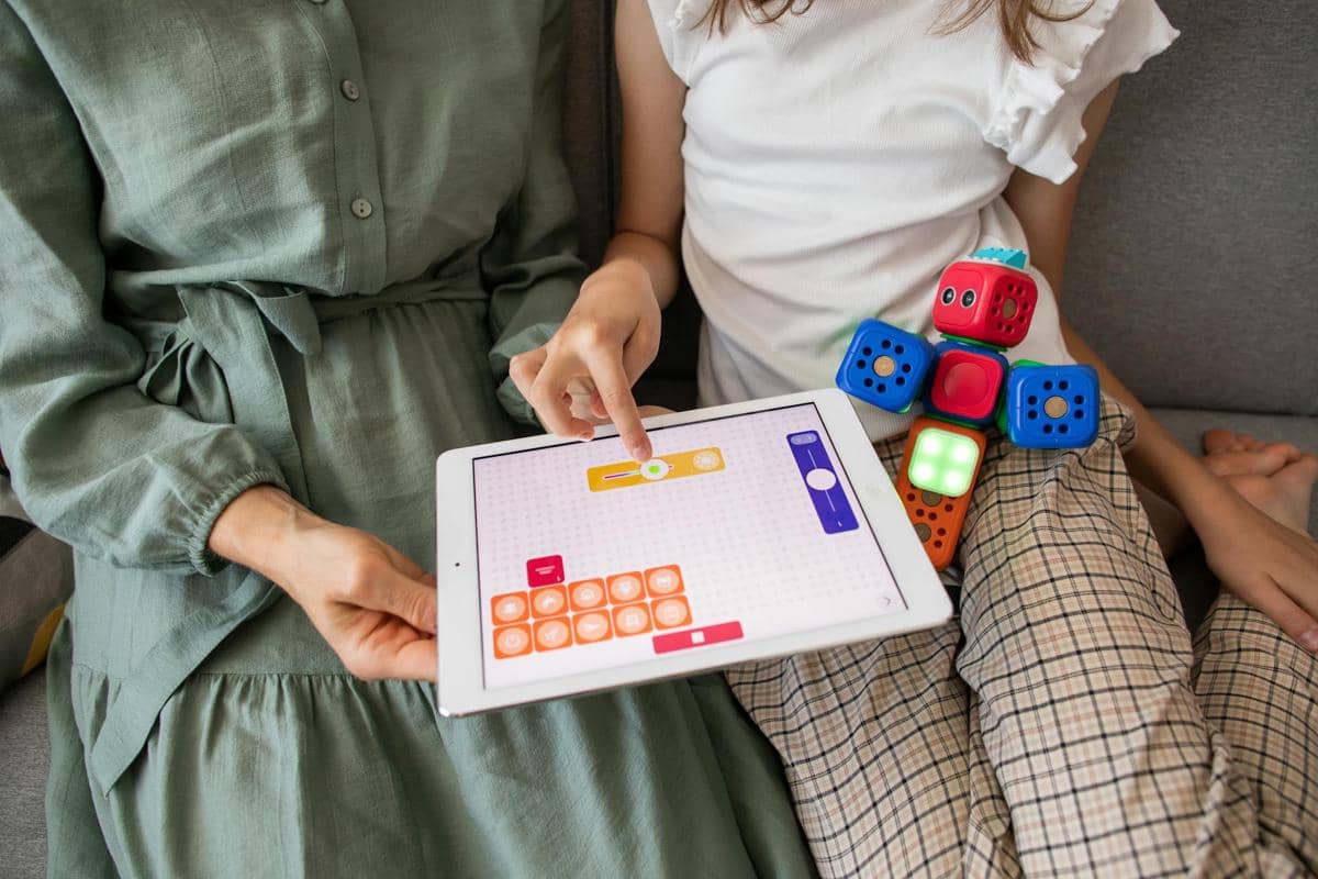 seorang ibu yang menggunakan gadget untuk mengajarkan anak