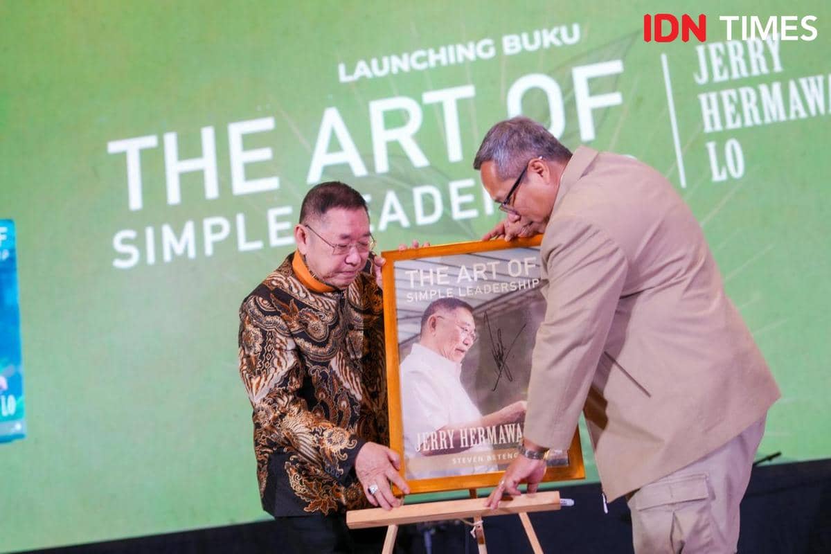Dua pria memegang bingkai berisi sampul buku The Art of Simple Leadership saat acara peluncuran di Tangerang.