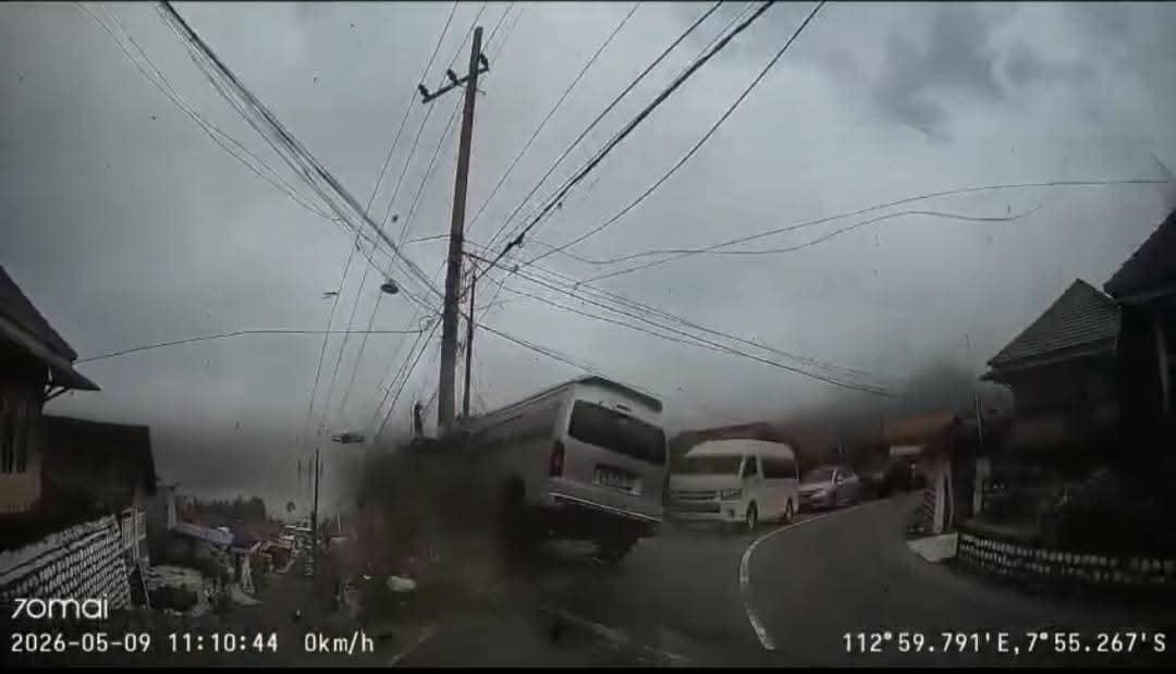Sebuah minibus Hiace tampak kehilangan kendali di jalan menurun dan berbelok di kawasan pegunungan Bromo dengan kondisi cuaca berkabut.