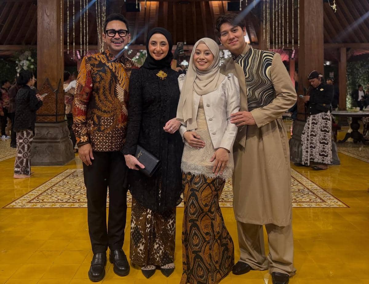 Empat tamu berpakaian batik dan busana tradisional berpose bersama di resepsi pernikahan anak Soimah di sebuah gedung bernuansa Jawa.