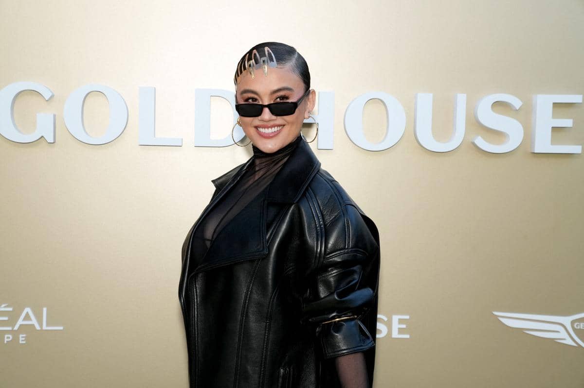 Seorang perempuan berpose dengan senyum lebar mengenakan jaket kulit hitam dan kacamata hitam di acara Gold House 5th Annual Gold Gala di Los Angeles.