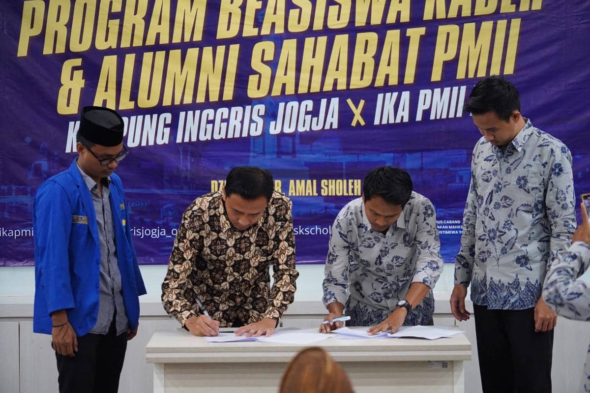 Perwakilan PW IKAPMII DIY dan Kampung Inggris Jogja menandatangani nota kesepahaman di depan spanduk kerja sama program beasiswa.