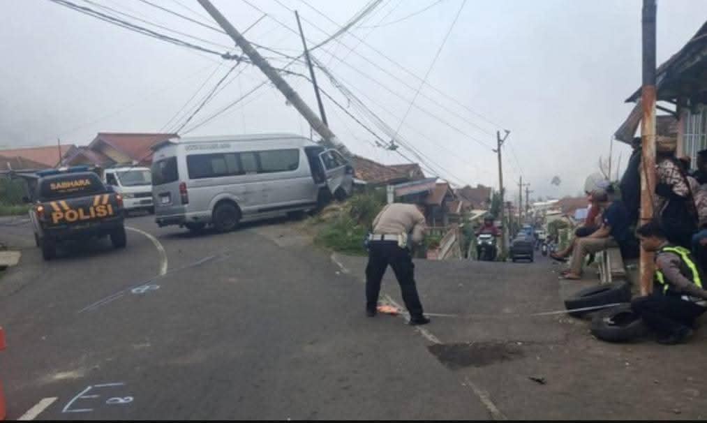 Petugas Satlantas Polres Probolinggo melakukan olah TKP kecelakaan di jalan menanjak dengan sebuah minibus menabrak tiang listrik.