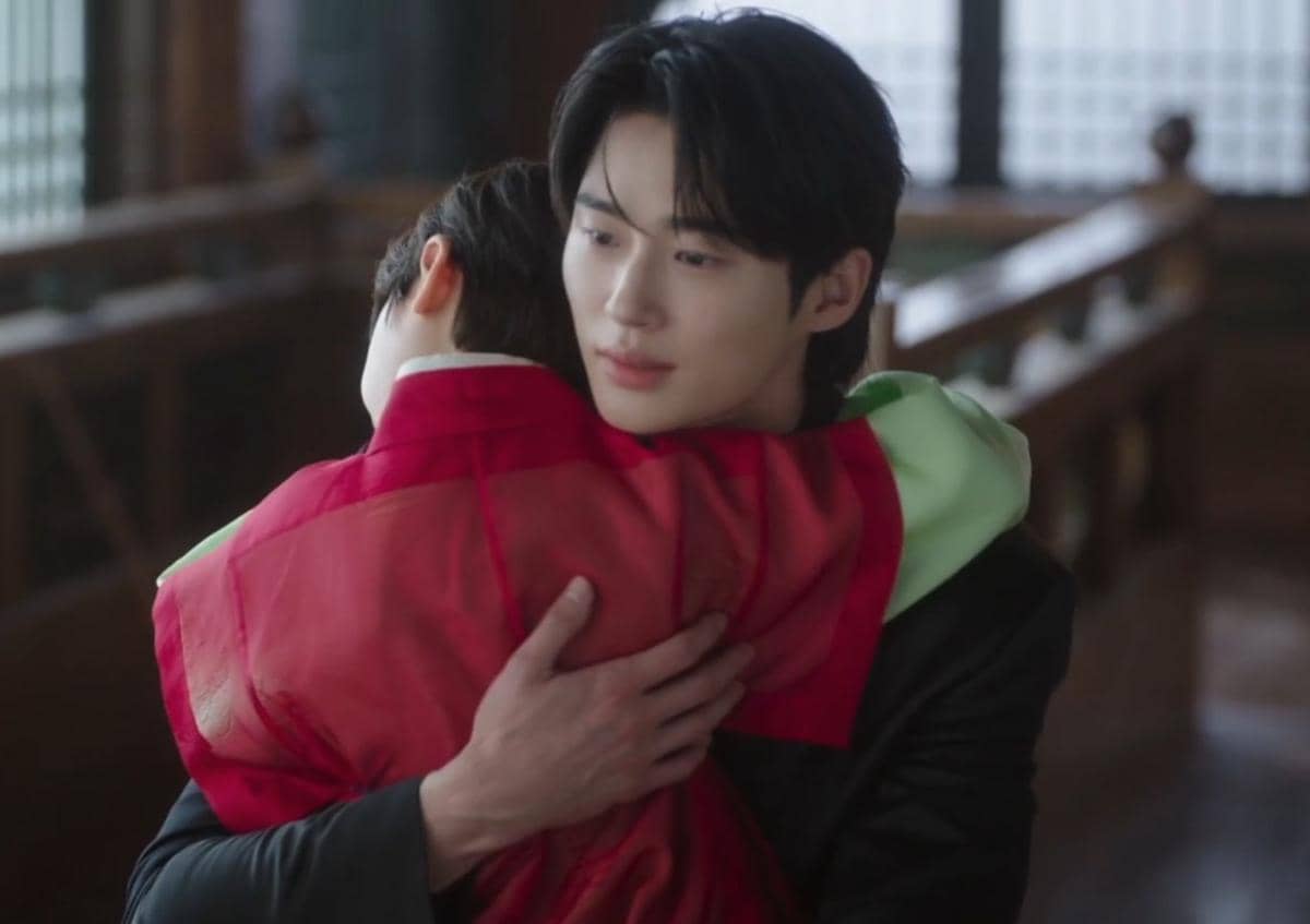 Dua karakter dalam drama Korea Perfect Crown berpelukan di dalam ruangan tradisional dengan pencahayaan lembut.