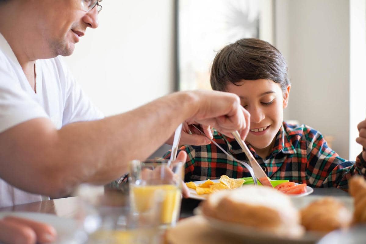 seorang ayah yang makan bersama anaknya
