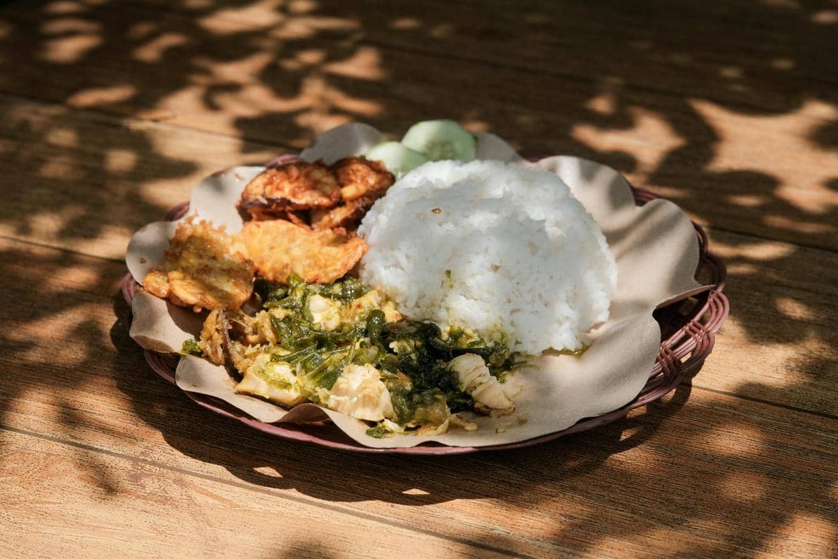 Ilustrasi nasi rames pedas khas madura di warung makan sederhana.