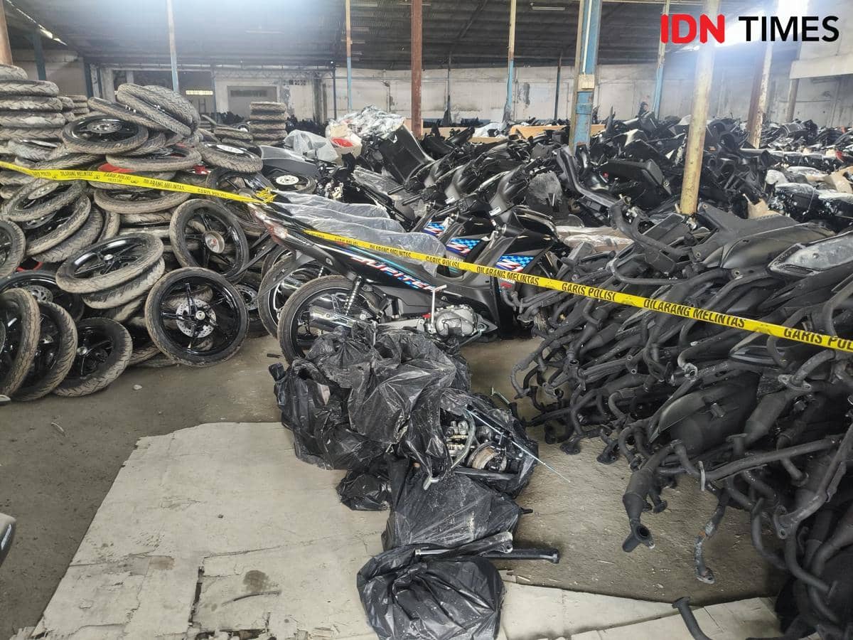 Deretan motor dan suku cadang yang disita polisi di gudang Jakarta Barat, dibatasi garis polisi dalam pengungkapan ekspor ilegal.