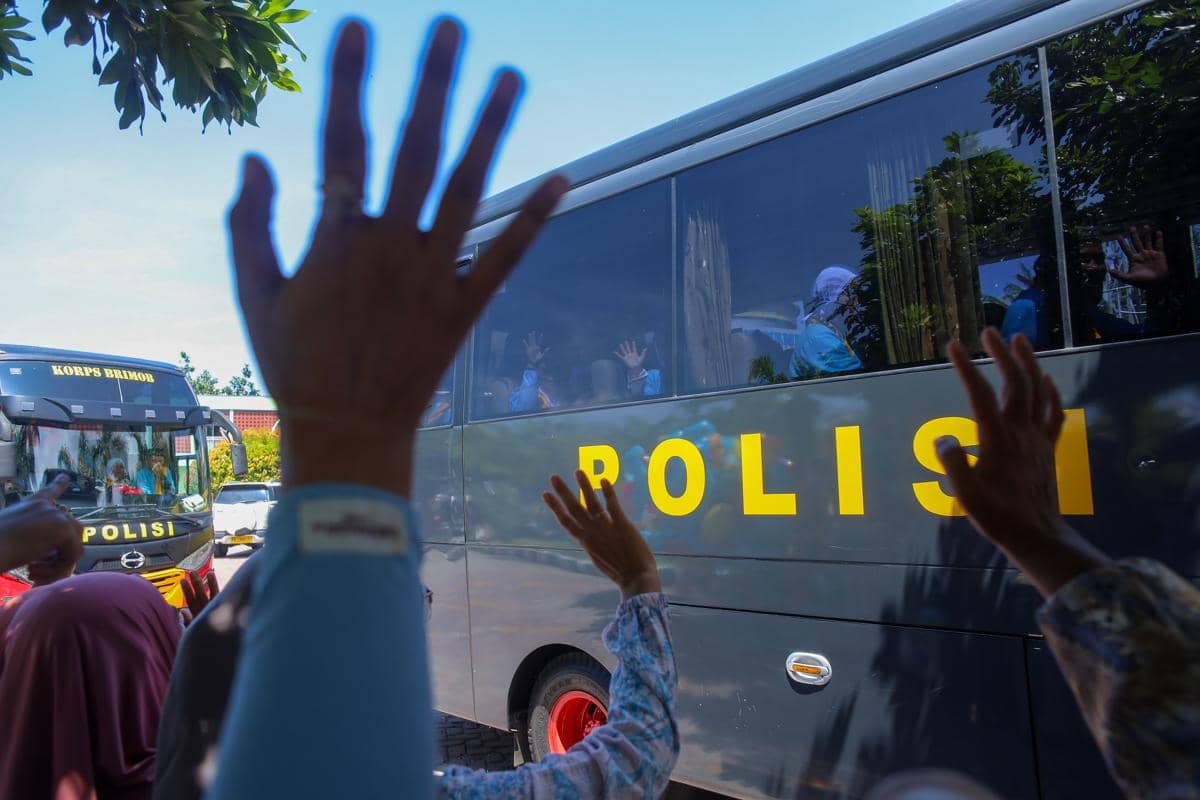 Calon haji melambaikan tangan dari dalam bus kepada kerabatnya saat pemberangkatan di halaman Masjid Ridwanul Bahri Manokwari, Papua Barat, 
