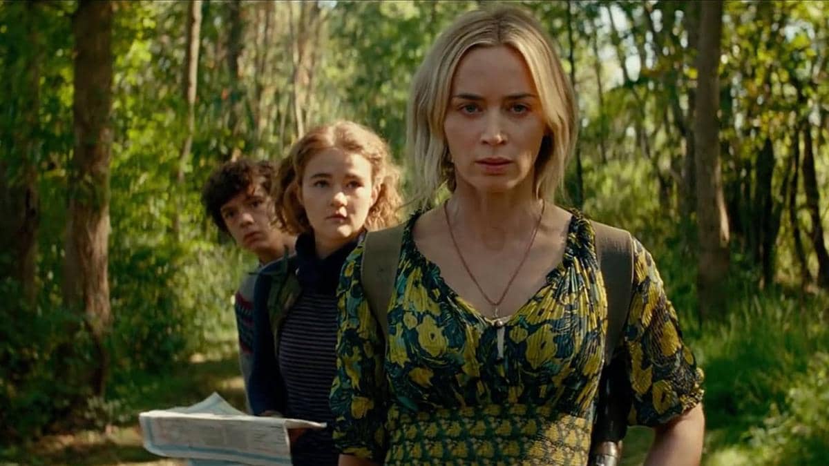 Tiga karakter berjalan di hutan dengan ekspresi waspada dalam adegan film A Quiet Place Part 2 produksi Paramount Pictures.