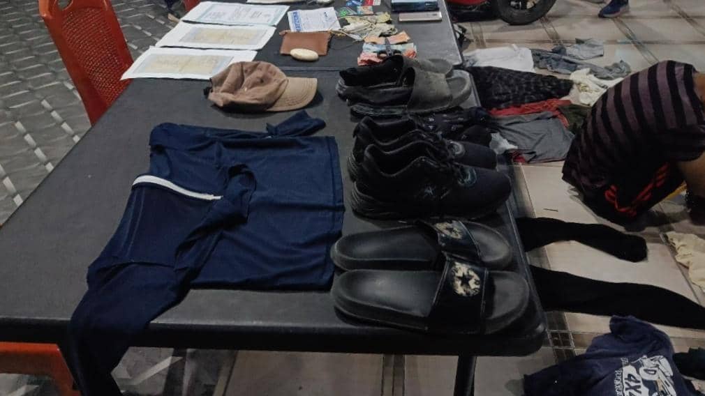 Barang-barang seperti pakaian, sepatu, sandal, dan dokumen diletakkan di atas meja hitam setelah penangkapan narapidana di Rote Ndao.