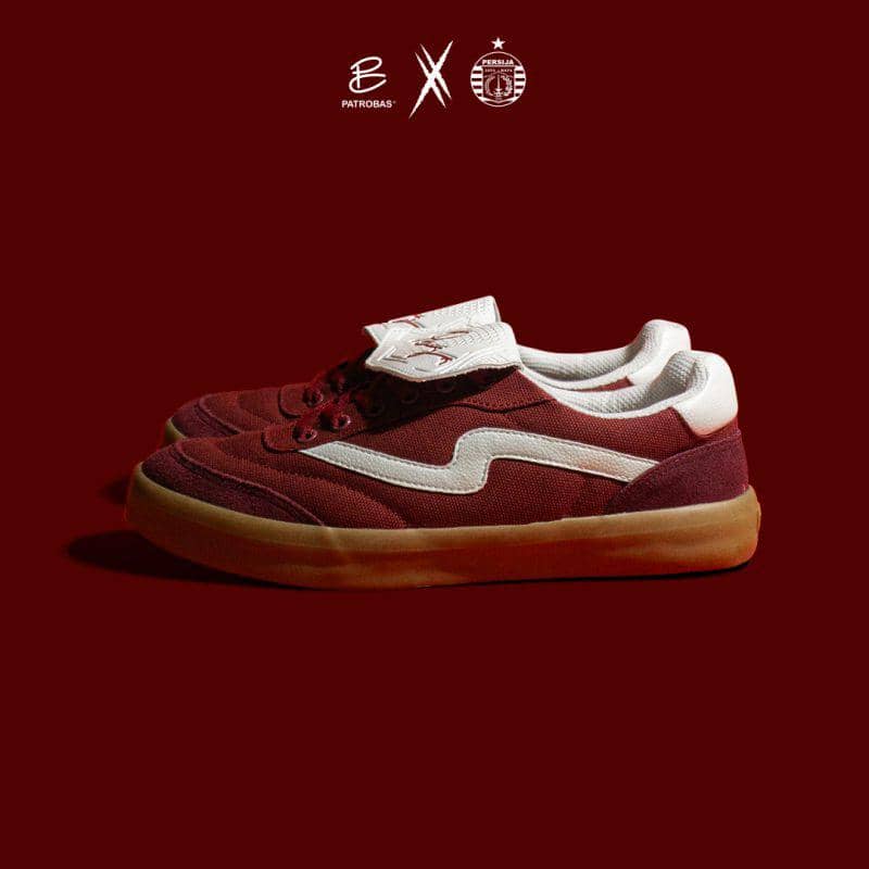 Sepasang sepatu kets berwarna merah marun dengan aksen putih dan sol karet cokelat, hasil kolaborasi Patrobas dan Persija Jakarta.