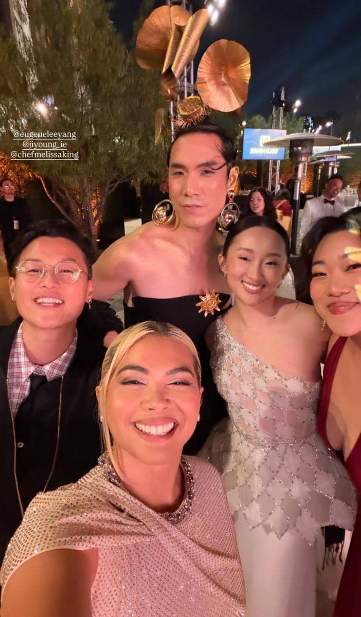 Sekelompok artis berpose bersama dengan busana glamor dan ekspresif di acara Gold Gala 2026 pada malam hari.