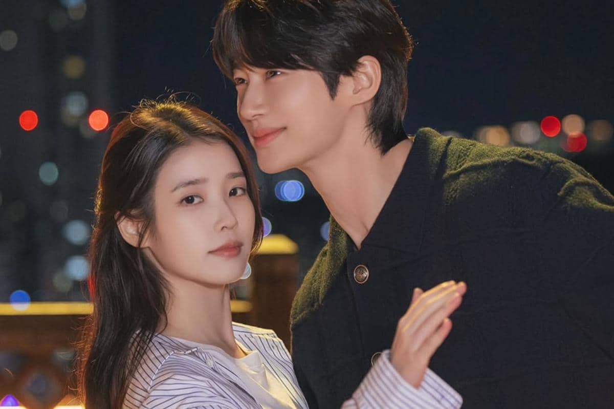 Dua pemeran utama drama Korea Perfect Crown berdiri berdekatan di malam hari dengan latar lampu kota yang berkilau.