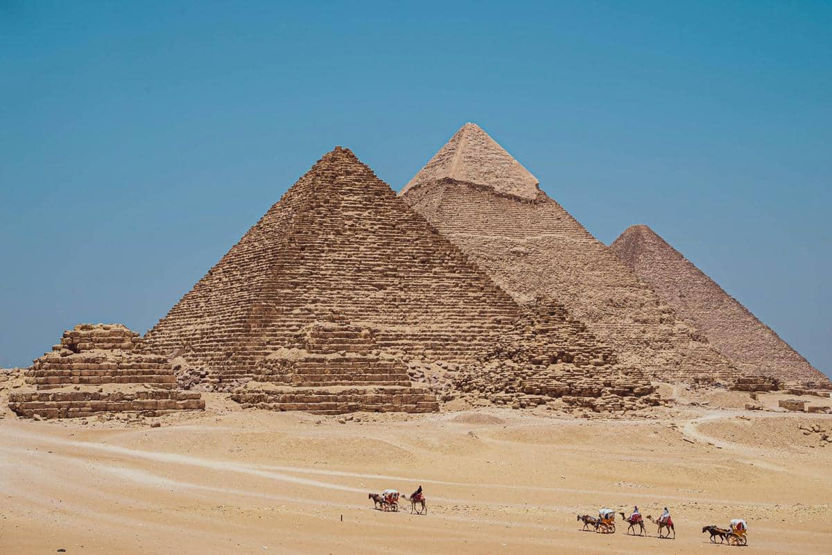 Nekropolis Giza di Mesir, yang menampilkan tiga piramida utama, yakni Piramida Agung Giza (depan), Piramida Khafre (tengah), dan Piramida Menkaure (belakang).