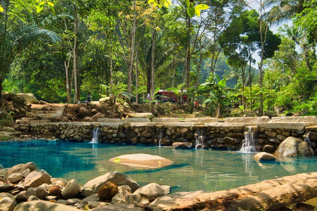Ilustrasi kolam pemandian alami dengan air pegunungan yang jernih dan segar.