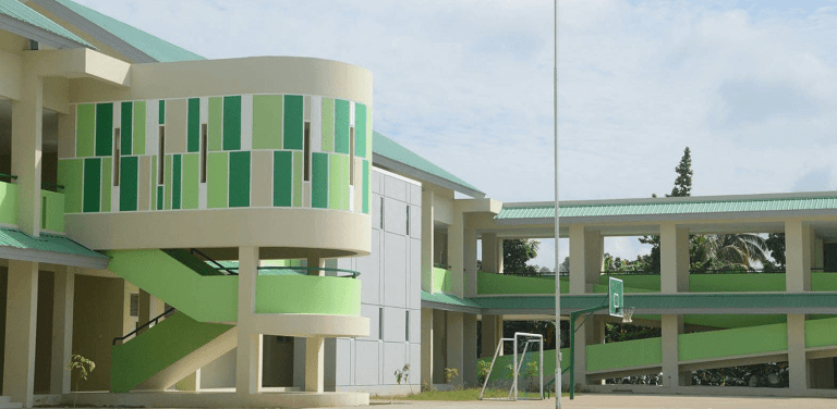 Bangunan sekolah SMAN 1 Pontianak dengan dinding berwarna hijau dan krem, menampilkan tangga melingkar serta halaman dengan ring basket.