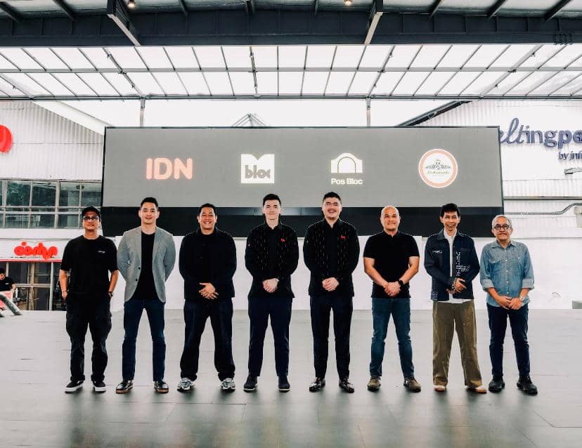 Pendiri IDN dan jajaran M Bloc Group berpose bersama di depan layar besar dengan logo IDN, M Bloc, Pos Bloc, dan M Bloc Space.