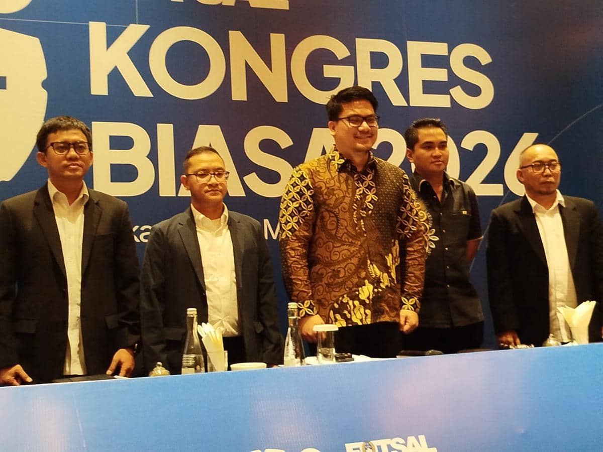 Lima pria berdiri di depan meja konferensi pers dengan latar belakang bertuliskan Kongres Biasa FFI 2024 berwarna biru.
