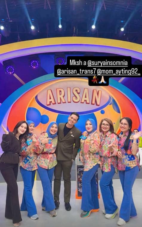 Beberapa orang berpose bersama di panggung acara kuis Arisan dengan latar warna cerah dan tulisan besar bertuliskan Arisan.