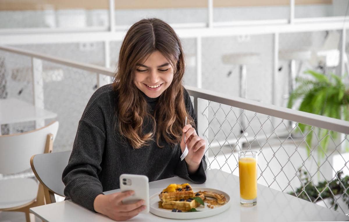 ilustrasi makan sambil scroll HP
