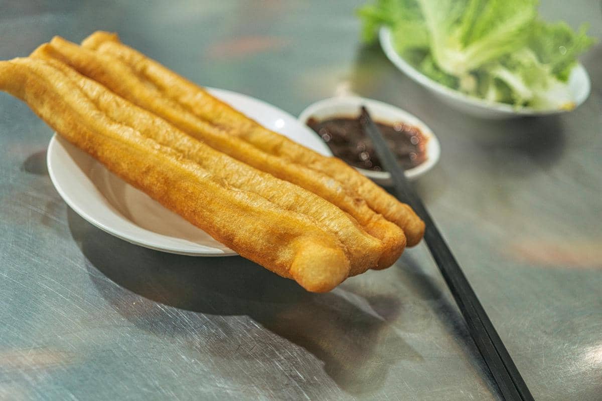 Ilustrasi cakue goreng hangat dengan tekstur renyah dan saus cocolan khas di pusat kuliner tradisional Surabaya.