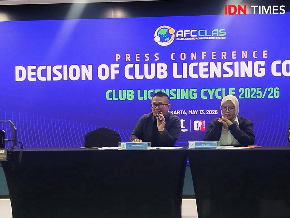 Dua pembicara duduk di meja konferensi pers Club Licensing Cycle 2025/26 dengan latar layar biru bertuliskan keputusan lisensi klub.