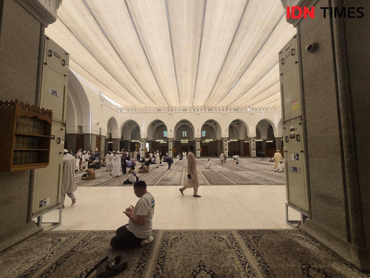 Jamaah sedang beribadah di dalam Masjid Quba dengan arsitektur megah, langit-langit tinggi, dan pencahayaan alami yang lembut.