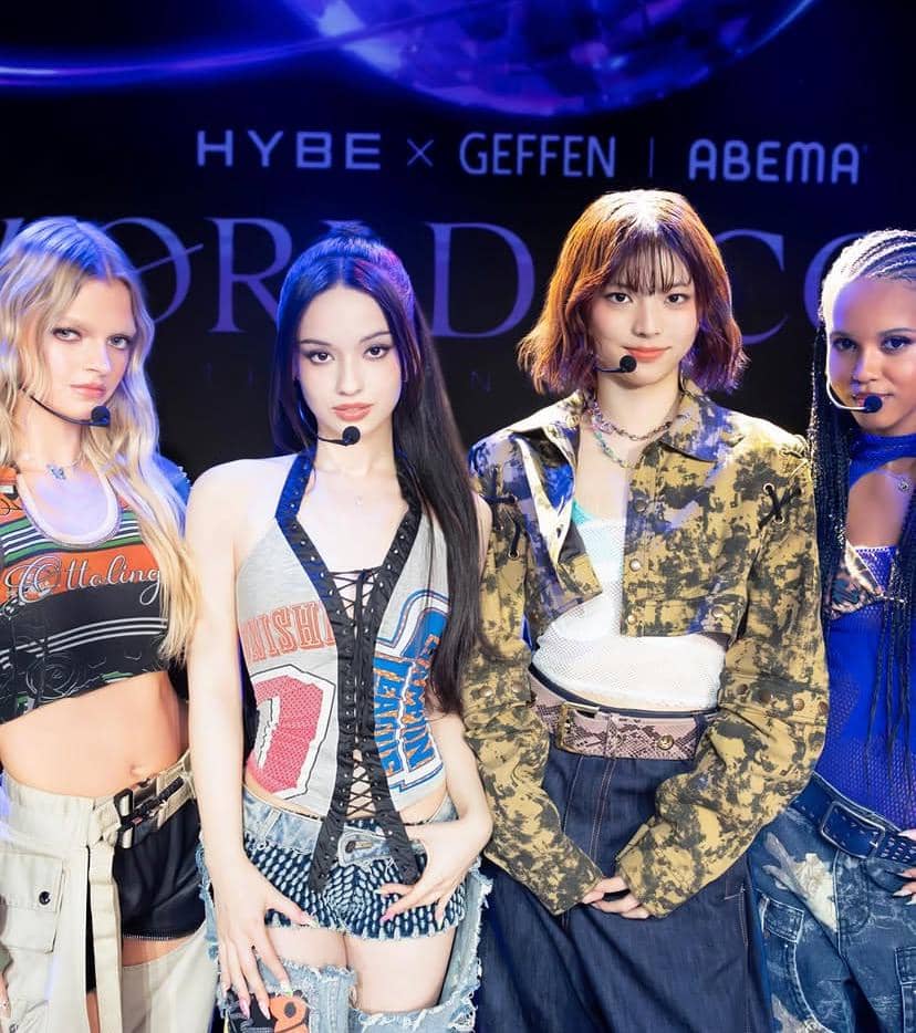 Empat anggota grup musik SAINT SATINE berpose di atas panggung dengan busana bergaya modern di bawah pencahayaan biru dan ungu.