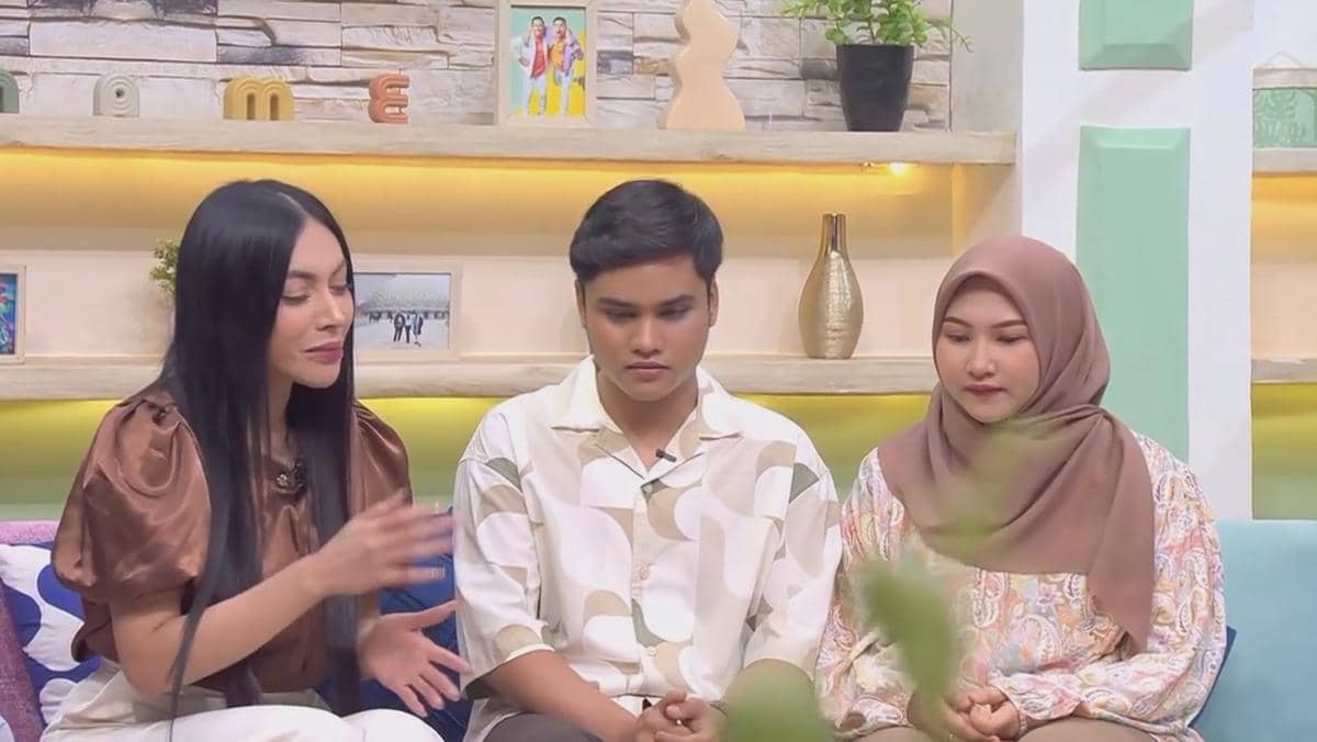 Tiga orang duduk di sofa acara televisi, seorang wanita berambut panjang berbicara dengan dua orang di sampingnya yang tampak mendengarkan.