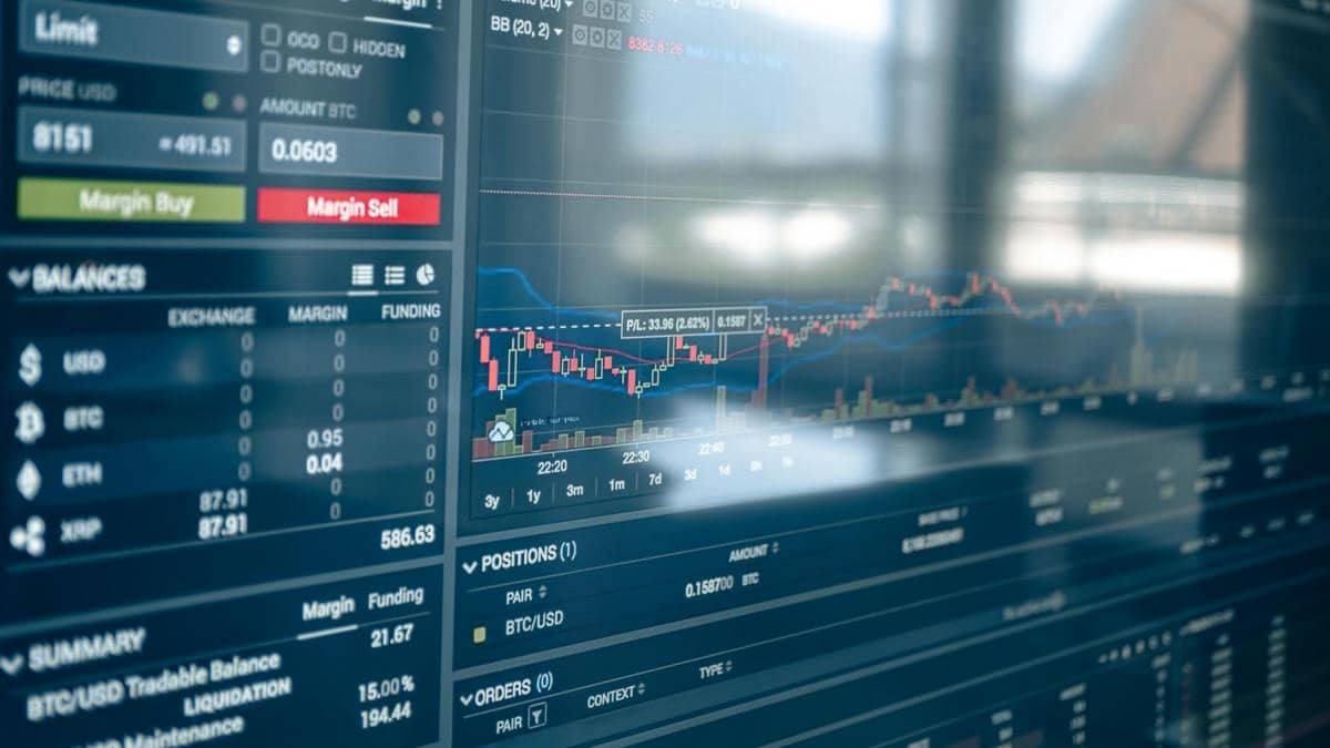 Tampilan layar komputer menampilkan grafik pergerakan saham dan data perdagangan dengan indikator harga serta volume transaksi.