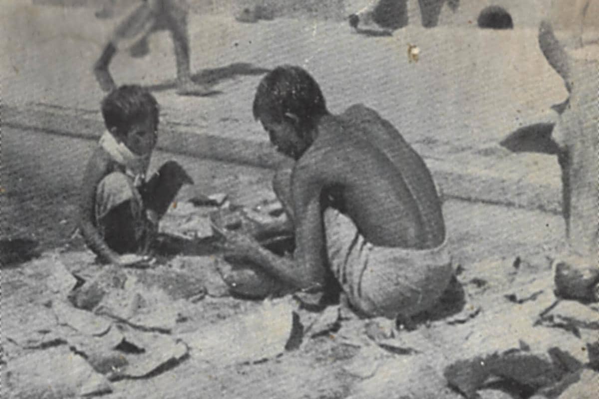 Seorang ayah, putranya yang masih kecil, dan seekor sapi sedang mencari sisa-sisa makanan di jalanan selama kelaparan Bengal tahun 1943.
